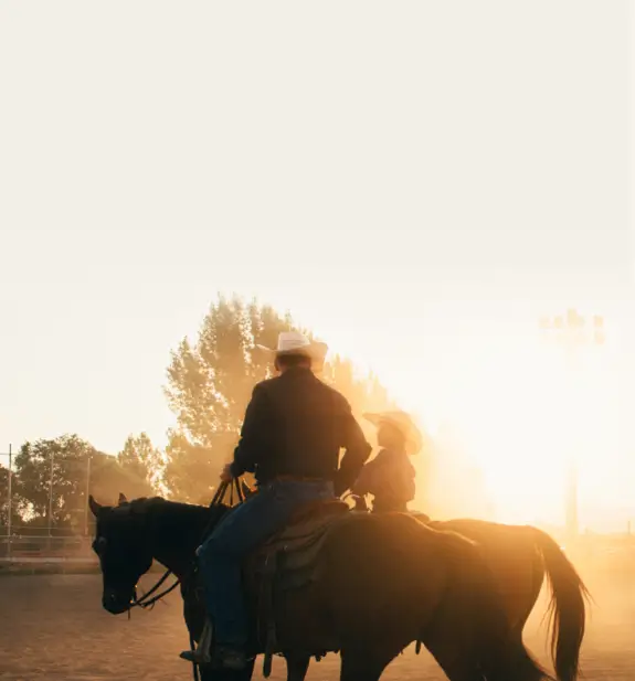 two cowboys riding horses