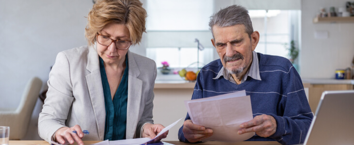 Elderly man sitting with younger woman, his power of attorney