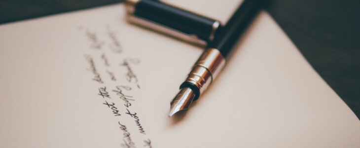 a dip pen laying on a hand-written will