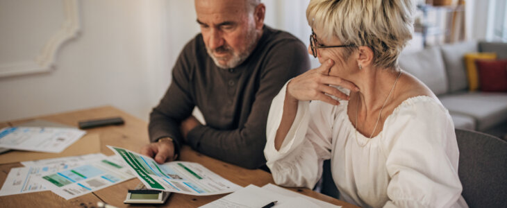 Couple calculating bills and taxes at home